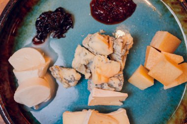 Peynir tabağında farklı çeşitte peynir kekik ve ceviz var..