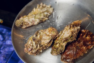 Dilimlenmiş limonla taze açılmış istiridye ezilmiş buzun üstünde fotokopi alanı ile sunuluyor..