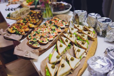 Burgerler, soğuk atıştırmalıklar, et ve salatalarla dolu açık büfe masası..