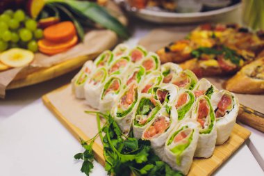 Burgerler, soğuk atıştırmalıklar, et ve salatalarla dolu açık büfe masası..