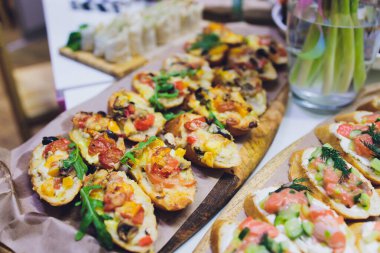 Burgerler, soğuk atıştırmalıklar, et ve salatalarla dolu açık büfe masası..