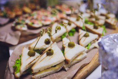 Burgerler, soğuk atıştırmalıklar, et ve salatalarla dolu açık büfe masası..