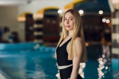 Güzel sarışın kadın yüzme havuzunda.