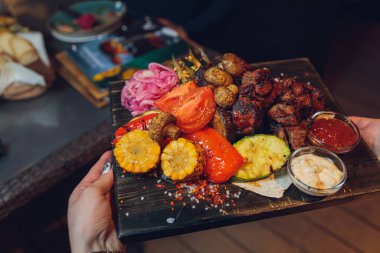 Izgara sebzeli biftek ve servis masasında baharat..