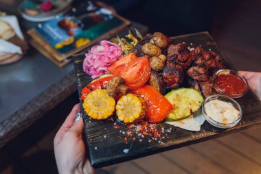 Izgara sebzeli biftek ve servis masasında baharat..