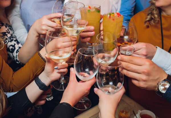 Clinking glasses with alcohol and toasting, party.