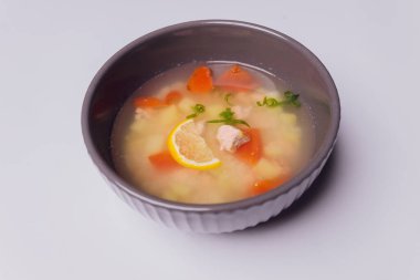 Kasede somon ve gri dokulu arka planda çavdar ekmeği dilimleri olan kremalı çorba, seçici bir odak noktası..