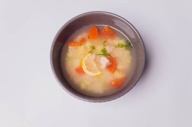 Kasede somon ve gri dokulu arka planda çavdar ekmeği dilimleri olan kremalı çorba, seçici bir odak noktası..