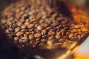 Kahve tanecikli cam bankası siyah arka plandaki bir masada..