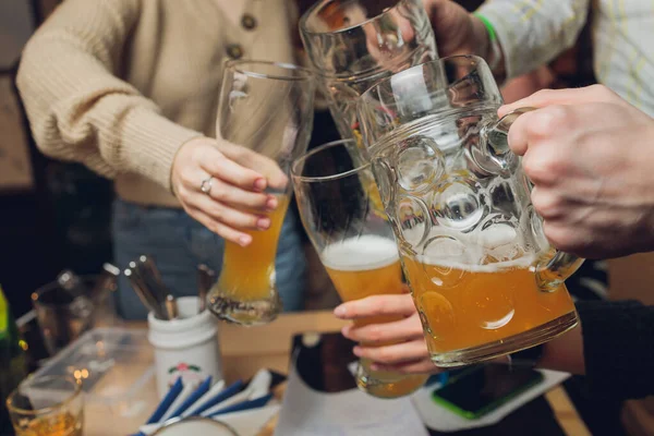 Fyra vänner med en färsk öl i en ölträdgård närbild på öl stein. — Stockfoto