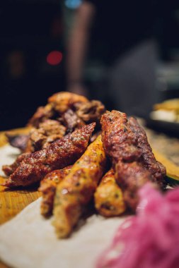 Tahtaya konmuş et. Kızarmış tavuk kanadı, domuz kaburgası, ızgara sebze, patates kızartması. Soslu bira aperatifi. arkaplan resmi.