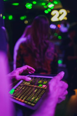 DJ rengarenk bulanık arkaplanda mikserde müzik çalıyor.