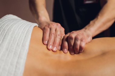 Beyaz tenli çekici bir kadın masaj yatağında uzanıyor..