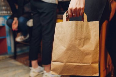 Çağdaş kafe kahve dükkanında, yemek dağıtımında, kafe restoranında, hazır yemek servisinde müşterileri bekleyen tatlı kağıdı torbası..