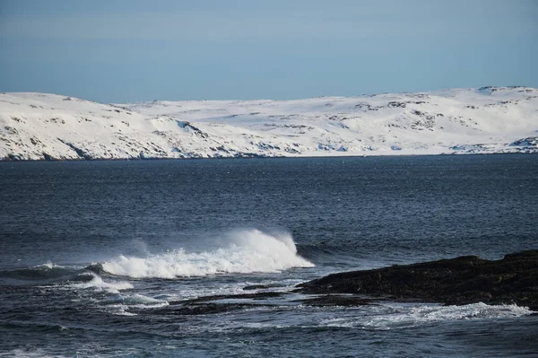 De petites vagues de mer se brisent contre les pierres du rivage. Une journée ensoleillée et une mousse blanche des vagues. La fonte des glaciers comme impact environnemental de la pollution atmosphérique. — Photo