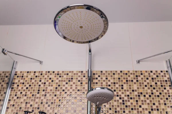 В ванной комнате, открытый душ смеситель прикреплен к настенной кронштейн, тонированное черно-белое изображение. — стоковое фото