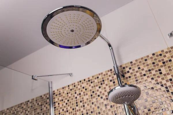 В ванной комнате, открытый душ смеситель прикреплен к настенной кронштейн, тонированное черно-белое изображение. — стоковое фото