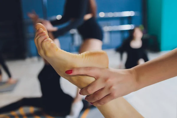 Fitness, sport, training, gym and lifestyle concept - κλείσιμο ατόμων με γυμναστή που γυμνάζει και τεντώνει το πόδι στο γυμναστήριο. — Φωτογραφία Αρχείου