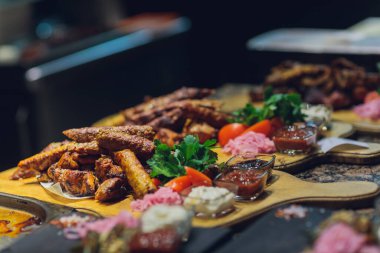 Siyah eldivenli adam beyaz tabakta yemek için spatulayla kuzu eti koydu. Lezzetli pişmiş kuzu eti.