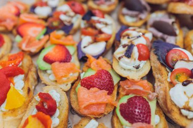 Burgerler, soğuk atıştırmalıklar, et ve salatalarla dolu açık büfe masası..