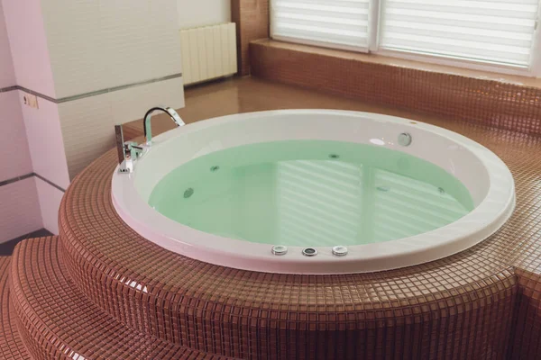 Гідромасажна ванна на мармуровій підлозі з водою . — стокове фото