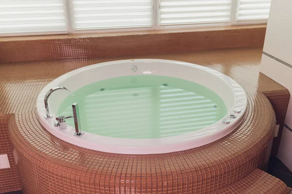 Джакузи ванна на мраморном полу с водой. — стоковое фото