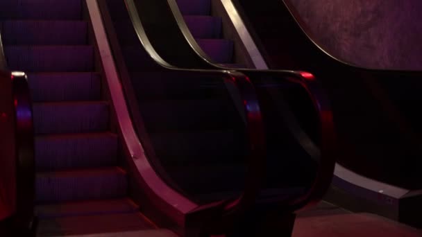 Poruszanie się po schodach ruchomych ze szklanymi bokami i metalowymi stopniami. — Wideo stockowe