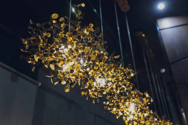 Caro lujo gran lámpara de araña detrás de vidrio con dorado. Reflexión en el escaparate. Luces en forma de velas. — Foto de Stock