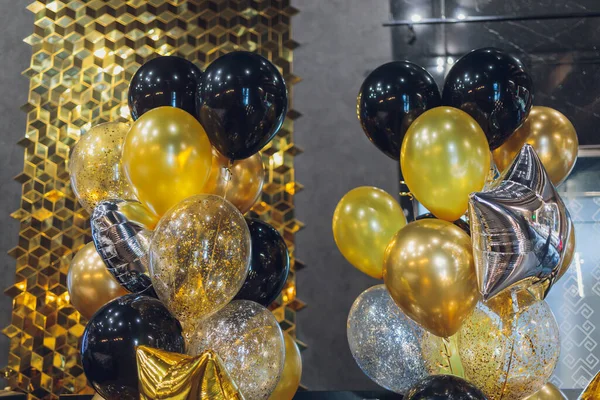 Balões de ar de hélio preto e ouro no fundo branco, comemorar, festa. — Fotografia de Stock