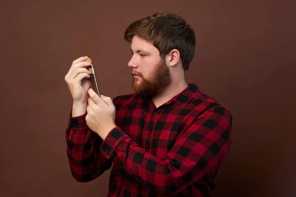 Man with emotions on his face with a beard on a brown background, logo, copy space. — Stock Photo, Image