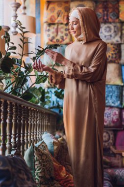 Kafede oturan Arap genç Müslüman kadın..