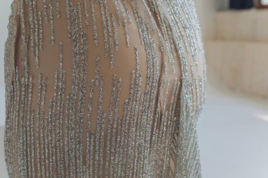 Narin bir yayı, yapay elmasları, nakışları ve parlak boncukları olan büyüleyici nedime elbisesi..