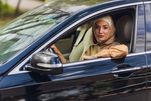 Mujer de Oriente Medio conduciendo un coche, mirando hacia el futuro. — Foto de Stock