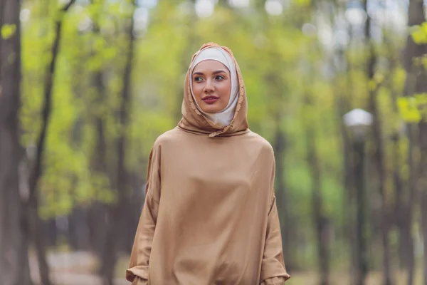 Mujer hermosa islámica en un vestido musulmán de pie en un parque de verano calle fondo bosque otoño trees.world hijab día. — Foto de Stock