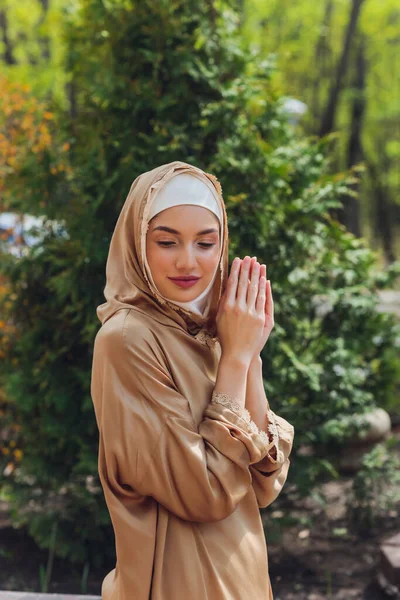 Islamische schöne Frau in einem muslimischen Kleid steht auf einem Sommer Park Straße Hintergrund Wald Herbst Bäume. Welt Hijab Tag. — Stockfoto