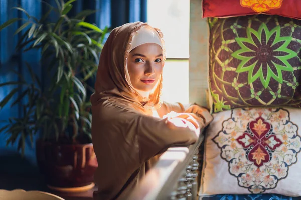 Arabische jonge moslim vrouw zittend in een cafe. — Stockfoto
