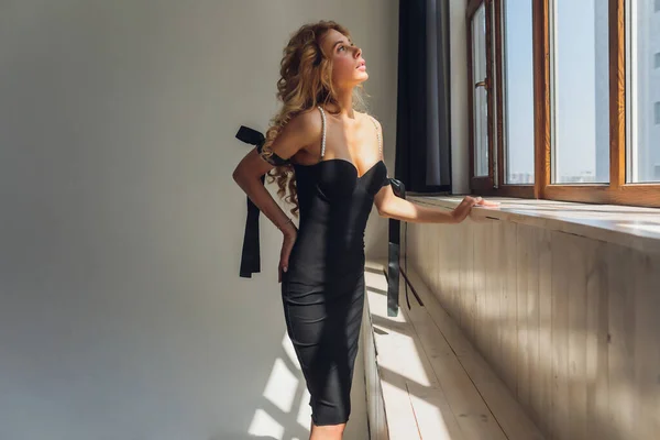 Mujer rubia de mediana edad en vestido negro posando sobre fondo gris. —  Fotos de Stock