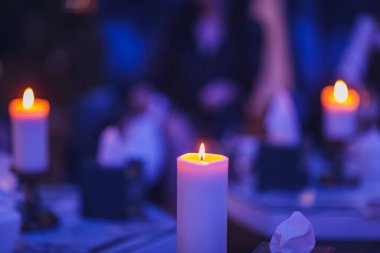 Mumlar koyu mavi arka plandaki mum standında yanıyor..