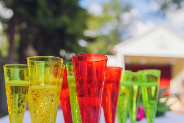 Misted glasses with multicolored cocktails with cocktail tubes close up.
