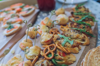 Burgerler, soğuk atıştırmalıklar, et ve salatalarla dolu açık büfe masası..