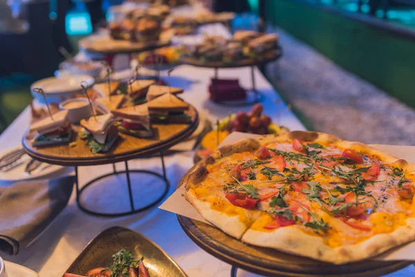 Bufetový stůl na hostinu, sendvič a pizzu. — Stock fotografie
