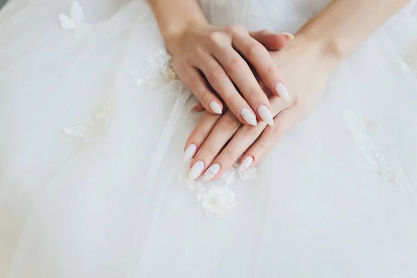 Noiva dobrou as mãos sobre os joelhos em expectativa de noivo. manhã de noivas. — Fotografia de Stock