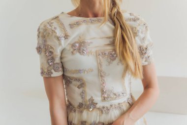 Gri arka planda poz veren orta yaşlı sarışın kadın..