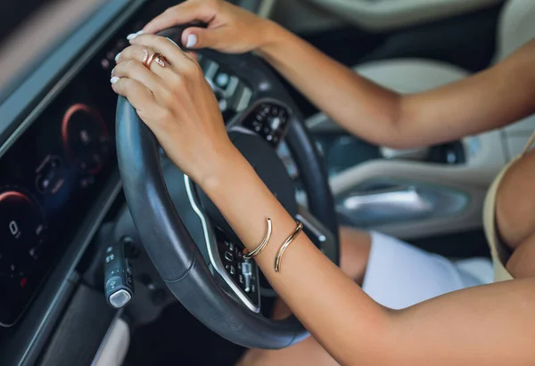 Close-up de uma mão de mulheres no volante em um carro moderno. — Fotografia de Stock