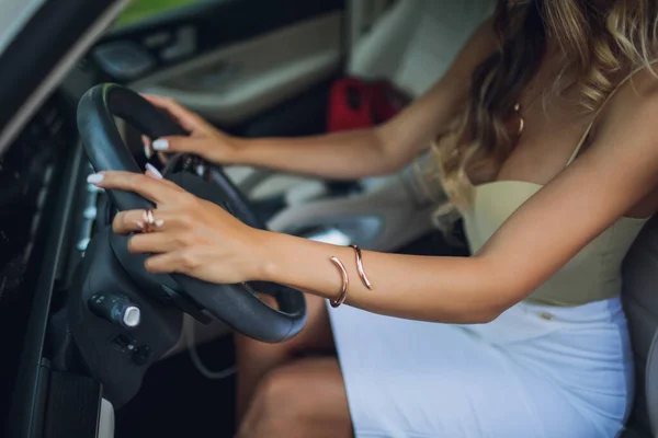 Zbliżenie kobiecej dłoni na kierownicy w nowoczesnym samochodzie. — Zdjęcie stockowe