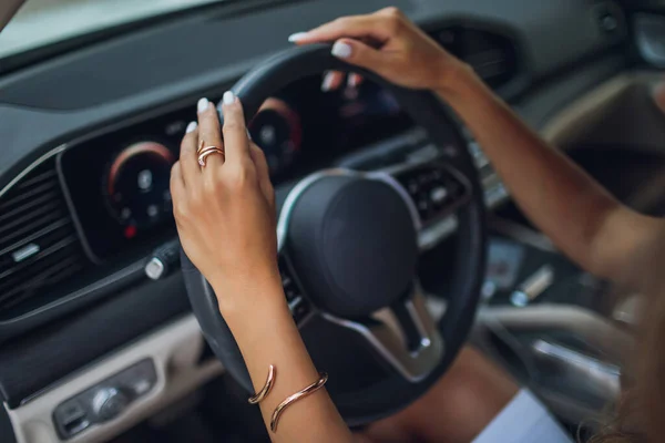 Gros plan d'une femme main sur le volant dans une voiture moderne. — Photo