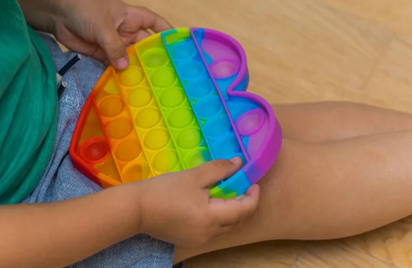 Brinquedo anti-stress pop it fidget baby boy hands. — Fotografia de Stock