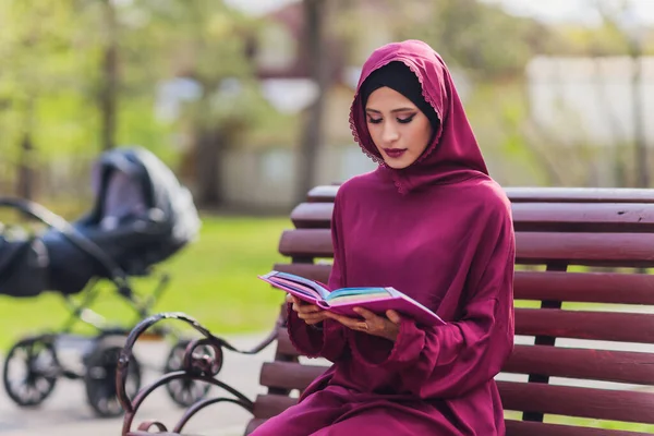 Selbstbewusster arabischer Geschäftsmann lächelt und spaziert durch Dubai. Arab Business vumen hijab ist auf den Straßen gegen die Wolkenkratzer von Dubai. Die Frau ist mit einer schwarzen Abaya bekleidet. — Stockfoto