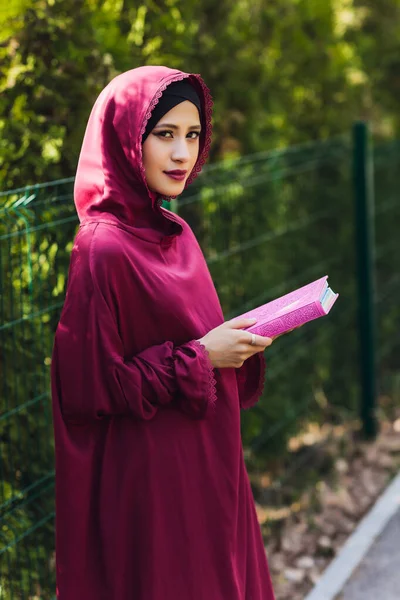 Selbstbewusster arabischer Geschäftsmann lächelt und spaziert durch Dubai. Arab Business vumen hijab ist auf den Straßen gegen die Wolkenkratzer von Dubai. Die Frau ist mit einer schwarzen Abaya bekleidet. — Stockfoto