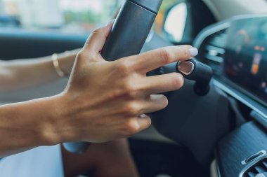 Kadınların elleri direksiyondaki dişli seçicinin loblarını değiştiriyor. El, araba vites kolunu değiştiriyor. El teçhizatı yakın çekim. Direksiyon simidinin küreğini değiştiriyor..